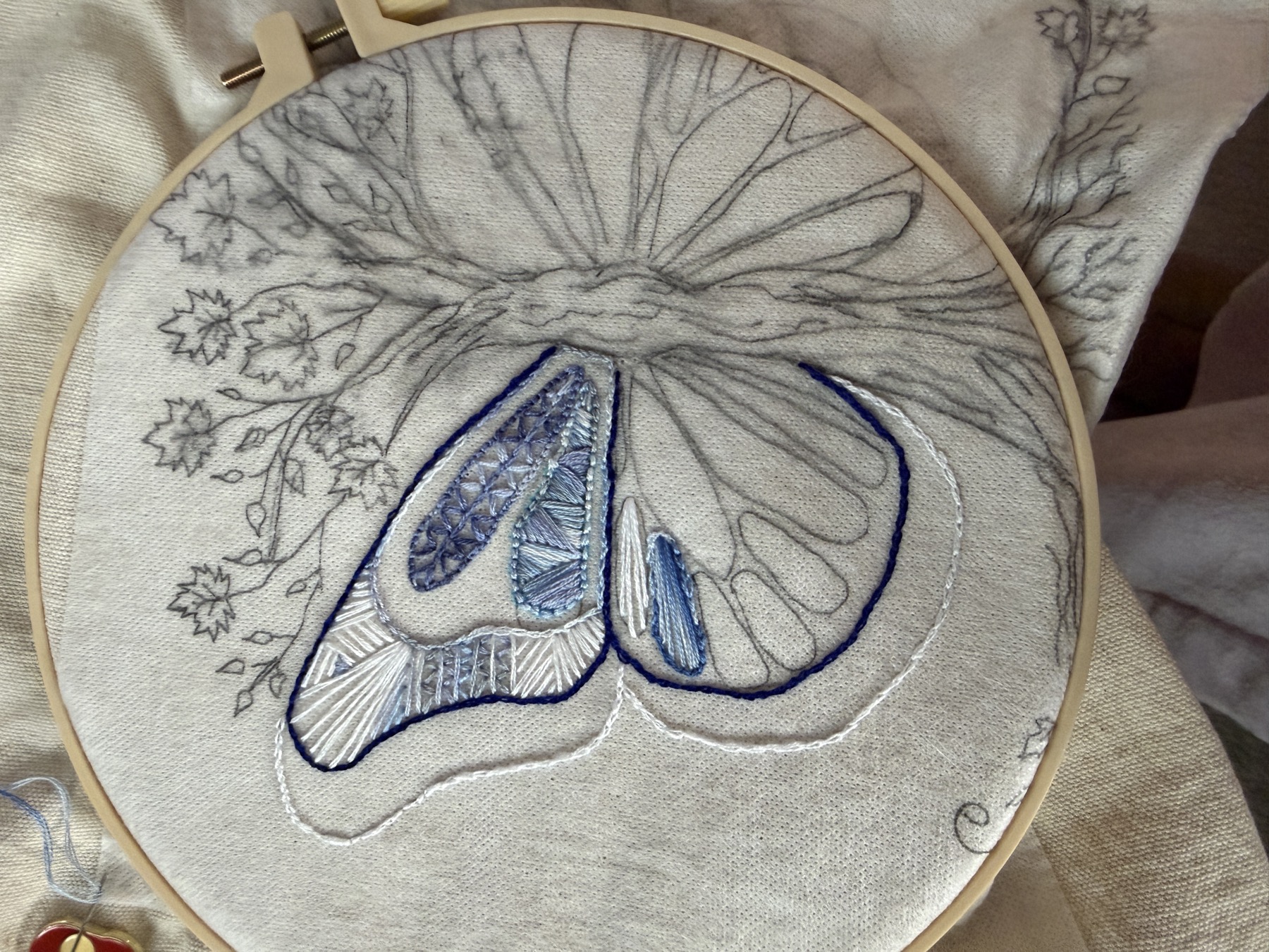 Early blue and white embroidery stitches worked inside a hoop.